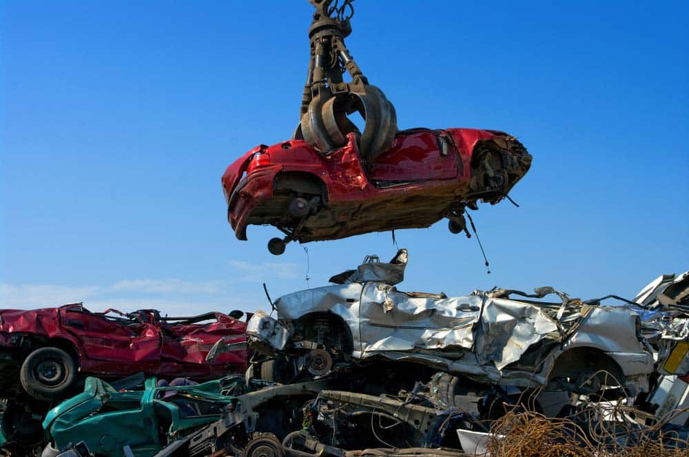 Crane Lifting A Red Scrap Car